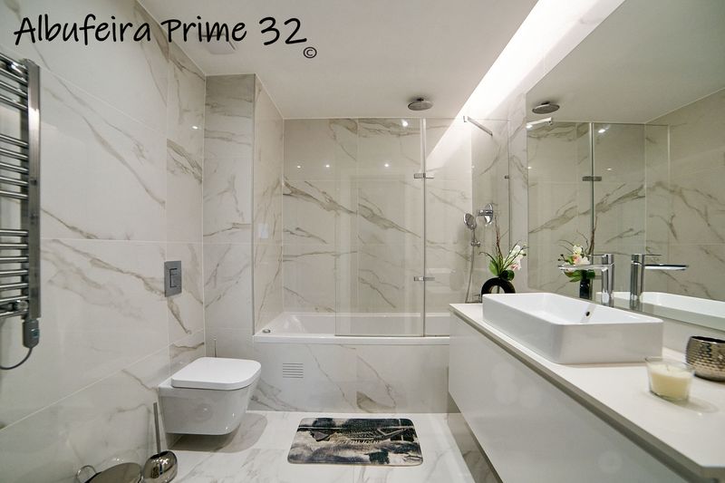 Marble en-suite bathroom with bath, shower screen and basin